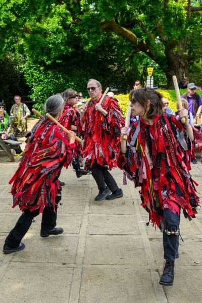 Dancers in vibrant traditional tatters perform an energetic stick dance at the New Forest Green Man Parade 2026, held at The Queens Head in Burley, Hampshire. This festive event showcases traditional folk performances to celebrate the local culture and the spirit of the Green Man in the heart of the New Forest. #jerryfennerphotography #newforestphotographer #greenmanparade #morrisdancing #burley #hampshire