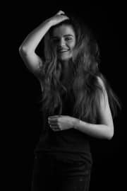 A joyful teenager poses during a professional photoshoot at The Studio on the Hill. This image is part of a collection of Teenage photographs, capturing a natural, expressive moment in monochrome to emphasize the subject's personality and the artistic quality of the session.#jerryfennerphotography#newforestphotographer#teenportrait#blackandwhitephotography#portraitphotography#studioonthehill