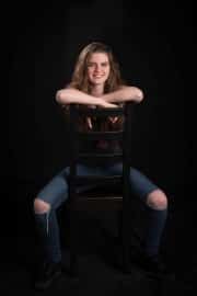 A joyful girl poses for their teenage photographs during a relaxed teenage portrait session at The Studio on the Hill, capturing an authentic and happy moment in a professional studio setting. #jerryfennerphotography #newforestphotographer #portraitphotography #teenagerportrait #studiophotography #youthphotography