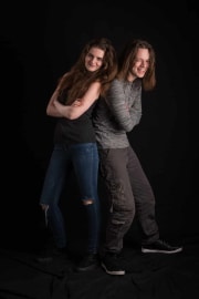 Two teenagers stand back-to-back during a fun portrait session at The Studio on the Hill. These teenage photographs were captured to celebrate their youthful connection and personalities in a professional studio setting. #jerryfennerphotography #newforestphotographer #teenportraits #studioonthehill #teenagers #portraitphotography